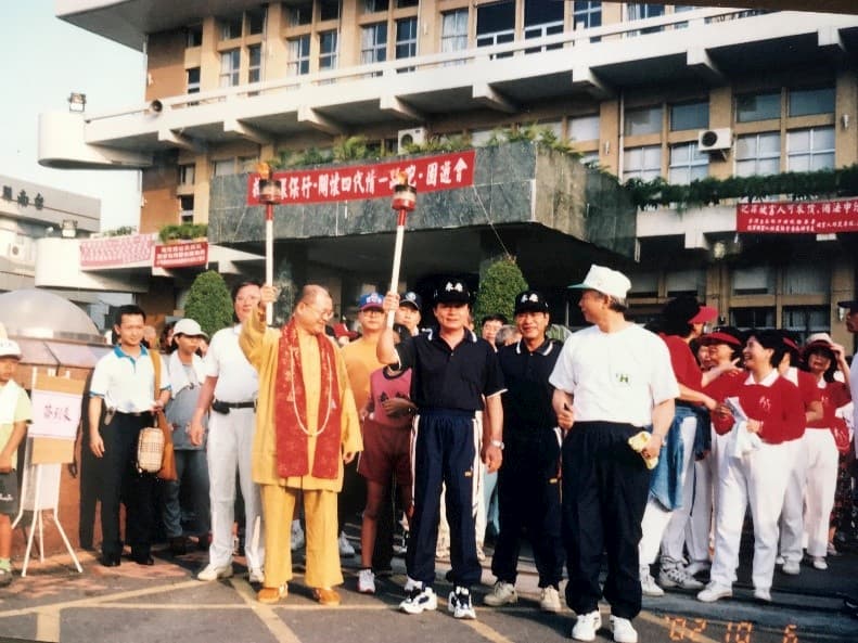 五三一.上師聖座2002年在台南縣永康市舉辦「戒煙環保行·關懷世代情」路跑環保公益活動。10月6日清晨，上師聖座與永康市長李坤煌帶領民眾一起路跑。